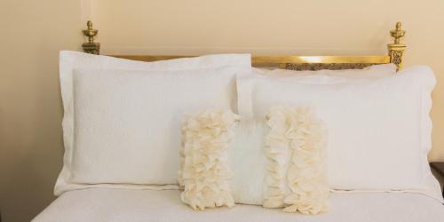 a group of white pillows on a bed at Teller House in Silverton
