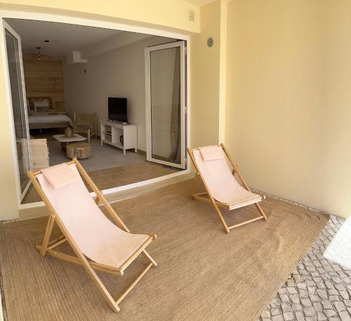 two chairs in an empty room with a television at Sesimbra Natural Room and private access in Sesimbra
