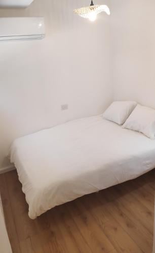 a white bed with white sheets and pillows at אחת ויחידה - One & Only in Ma'alot Tarshiha