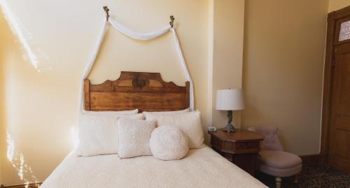 a bedroom with a white bed with a wooden headboard at Teller House in Silverton