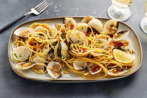 a plate of pasta with seafood on a table at I Fichi D'India Rooms in Capo Vaticano