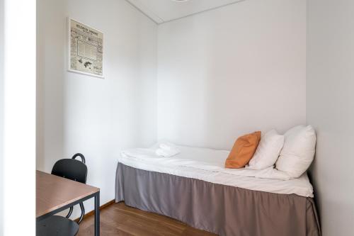 a bed in a room with white walls at Hiisi Hotel Helsinki Jätkäsaari in Helsinki