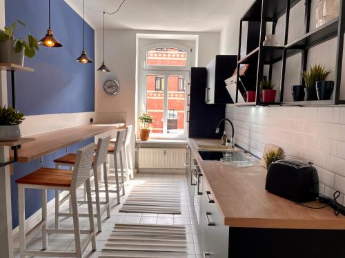 a kitchen with blue walls and wooden counter tops at City Gästeapartment Leipzig Zentrum-Ost in Leipzig