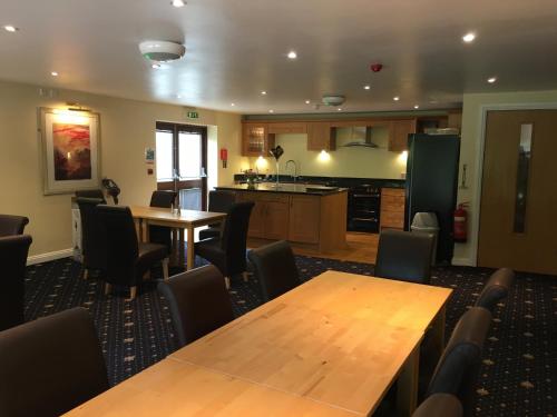 a kitchen and dining room with wooden tables and chairs at Cameley Lodge - Self Catering in Temple Cloud