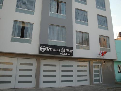 a building with two garage doors and a sign on it at Hotel Terrazas Del Mar in Huacho