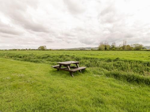a picnic table sitting in the middle of a field at Carthouse in Weston-super-Mare