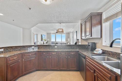 eine große Küche mit Holzschränken und einem Waschbecken in der Unterkunft Bristol 610 - Spacious Corner Unit w/ Large Balcony & Gorgeous Beach View! in Gulf Shores