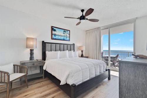 ein Schlafzimmer mit einem Bett mit Deckenventilator und einem Balkon in der Unterkunft Bristol 610 - Spacious Corner Unit w/ Large Balcony & Gorgeous Beach View! in Gulf Shores