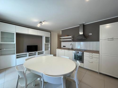 a kitchen with a white table and white chairs at Residence Ambria in Grado