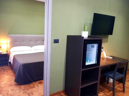 a bedroom with a bed and a desk with a television at Hotel Europa Art Caserta in Caserta