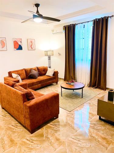 a living room with two couches and a table at AIDEN HOMES AND APARTMENTS HOTEl in Koforidua