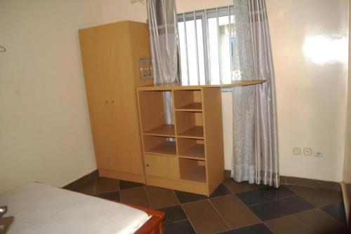 a bedroom with a book shelf and a window at Bénin Berge hotel in Cotonou