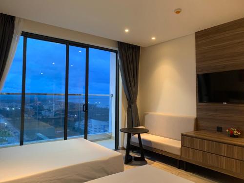 a hotel room with a bed and a large window at Win Condotel Apec Phú Yên in Tuy Hoa