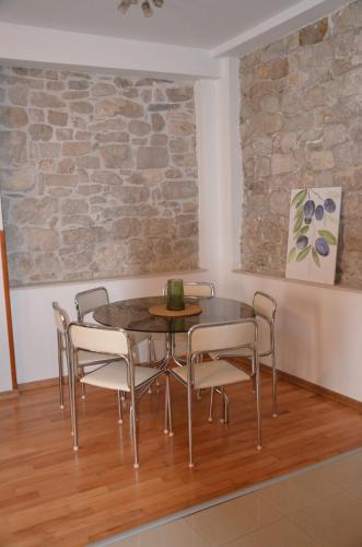 een tafel en stoelen in een kamer met een stenen muur bij DoLa Split in Split