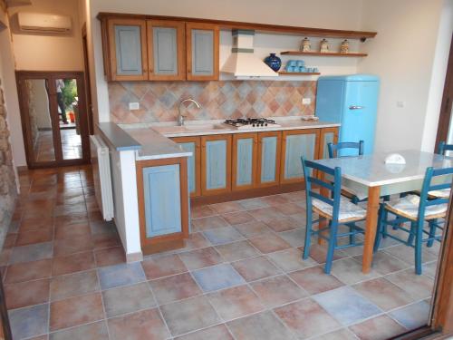 a kitchen with a table and a table and chairs at Villatramontistella Suite in Capoliveri