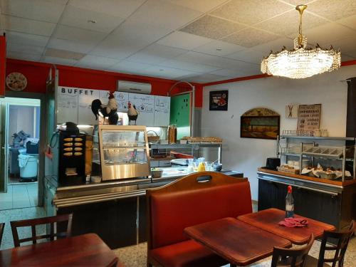 a fast food restaurant with a table and a counter at Hôtel Le Passage de Vallon in Vallon-Pont-dʼArc