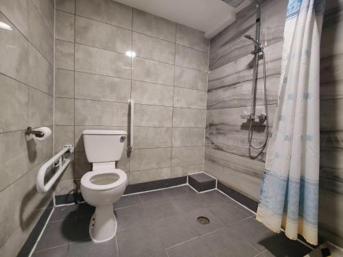 a bathroom with a toilet and a shower at Wellesley Hotel in Ilford