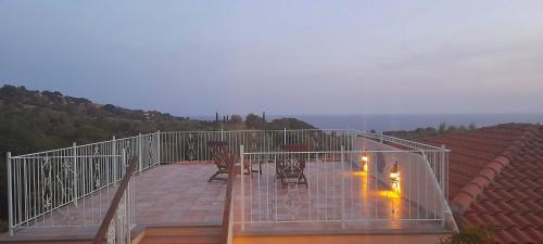 a balcony with chairs and lights on a roof at Villatramontistella Suite in Capoliveri