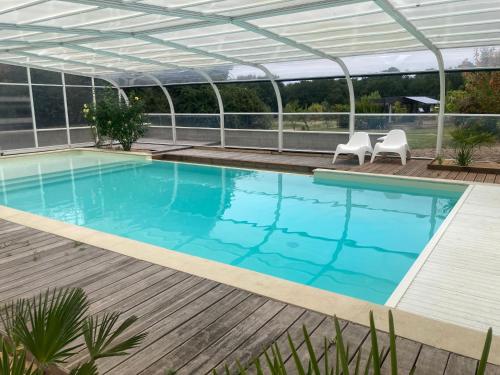 a swimming pool with a pergola and a swimming poolvisor at Les Pierres D'aurèle Chambres d'Hôtes in Saint-Georges-sur-Cher