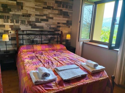 a bedroom with a bed with towels on it at Apartamentos La Corona in Parres de Llanes