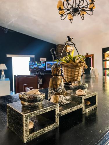 a statue of a buddha sitting on a table at RocaMar Hostel Boutique in Punta del Este