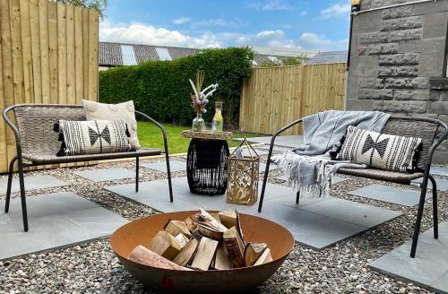 a patio with two chairs and a fire pit at Stylish & Chic Central Apartment with Hot Tub in Perth
