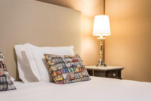 ein Bett mit einem Kissen und einer Lampe auf einem Tisch in der Unterkunft GuestReady - Office Residence 3 in Porto