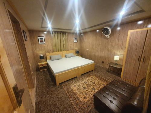 a bedroom with a bed and a couch in it at Sehrish Guest House Skardu in Skardu