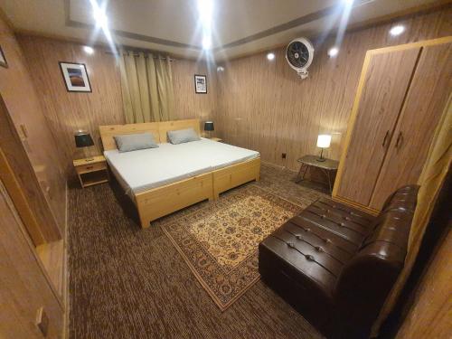 a bedroom with a bed and a leather couch at Sehrish Guest House Skardu in Skardu