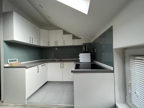 a kitchen with white cabinets and a sink at Ilidza Blue Nest in Sarajevo