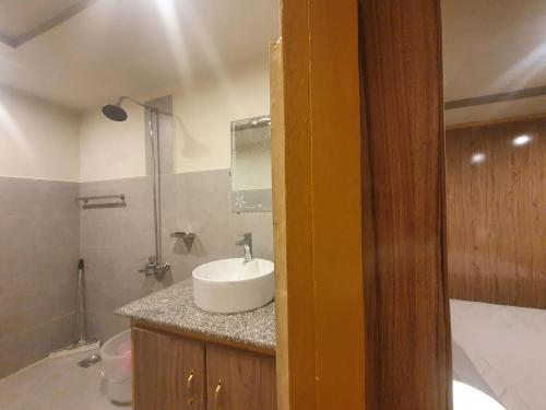 a bathroom with a white sink and a shower at Sehrish Guest House Skardu in Skardu