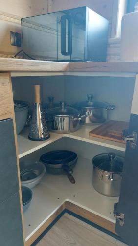 a shelf filled with pots and pans in a kitchen at Domek nad Czerwienią in Przesieka