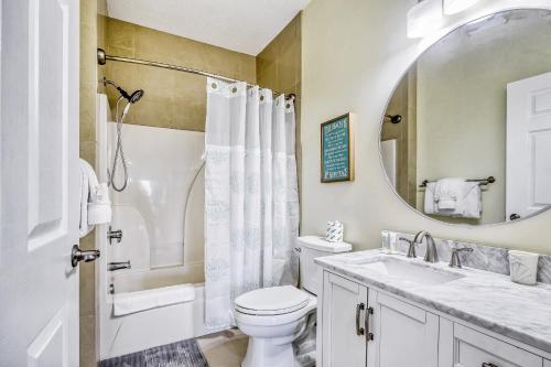 a bathroom with a toilet and a sink and a mirror at Plantation Harbour G-16 in Little River