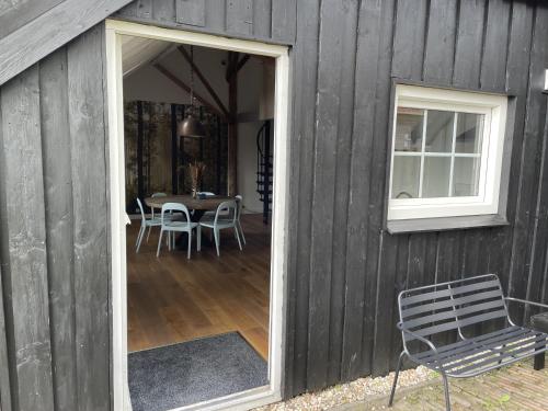 a barn with a door open to a dining room at B&B Woudzicht in Oudeschoot