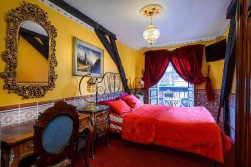 a bedroom with a red bed and a mirror at Hotel Mozart in Brussels