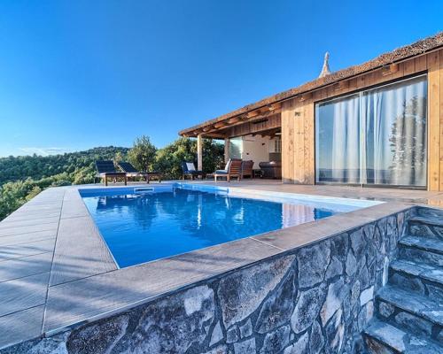 una piscina frente a una casa en Golden Haven Luxe Bungalow Resort en Murter
