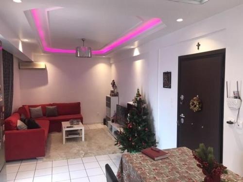 een woonkamer met een kerstboom en roze verlichting bij Enjoy the silence and view in Athene