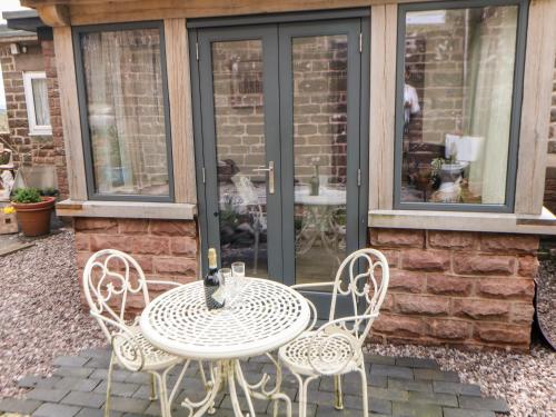 a white table and chairs on a patio at The Netty in Buxton
