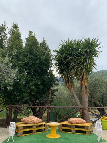 a picnic table and chairs and a table and a palm tree at Casa Vacanze Magistro in Patti