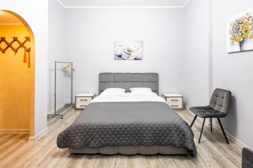 - une chambre avec un grand lit et une chaise dans l'établissement Apartments Galitskaya street, à Lviv