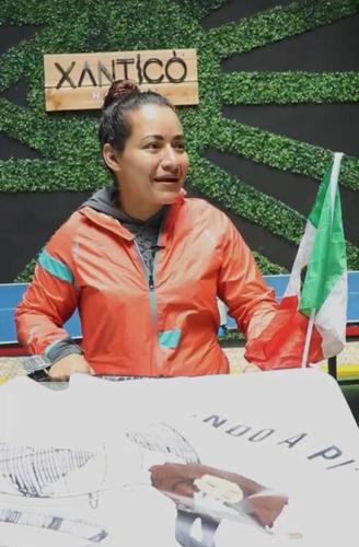 a woman sitting at a table with a flag at XanticoHostal in Ipiales