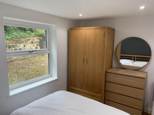 um quarto com um espelho, uma cama e uma cómoda em Headingley Excellent 1 bedroom apartment em Leeds