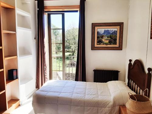 a bedroom with a bed and a large window at Albergue Villa San Clemente in Tui