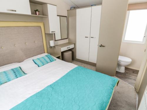 a bedroom with a large bed and a toilet at Moonlight Lodge in Morpeth