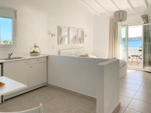 a white kitchen with a view of the ocean at Palm Suite Green in Porto Heli