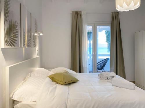 a white bed with two pillows on top of it at Palm Suite Green in Porto Heli