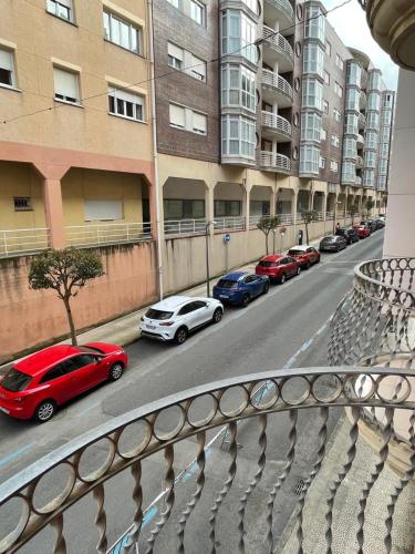 una fila de autos estacionados en una calle con edificios en Piso céntrico a 10 min de la playa con garaje incluido, en Castro Urdiales