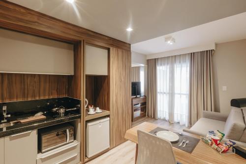 a living room with a kitchen and a dining room at Mercure Curitiba Batel in Curitiba