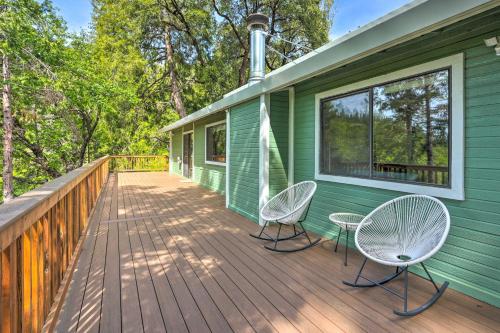 a green house with two chairs on a deck at 10 Acres with Stunning Views Apple Hill Home! in Camino