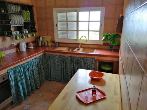 una cocina con fregadero y una mesa con una botella. en Casa María - Finca Medina, en Alojera